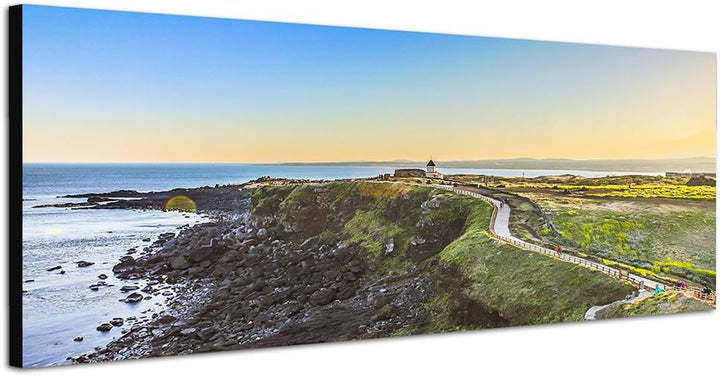 Paul Sinus Art Panoramabild auf Leinwand und Keilrahmen 150x50cm Meer Küste Strasse Wiese Kirche