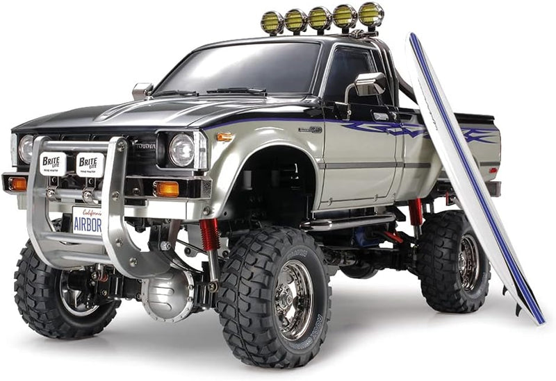 TAMIYA TMYTAM58397 1:10 RC Toyota HiLux HighLift 4x4 3-Gang - ferngesteuertes Auto - inkl. Surfbrett