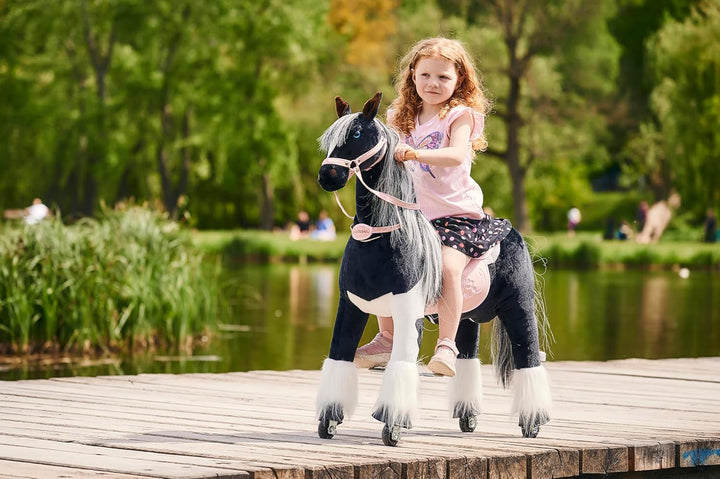 PONNIE Reitpferd mit Rollen Domino M (5-12 Jahre), Spielpferd zum Reiten mit Abnehmbarer Rosa Sattel