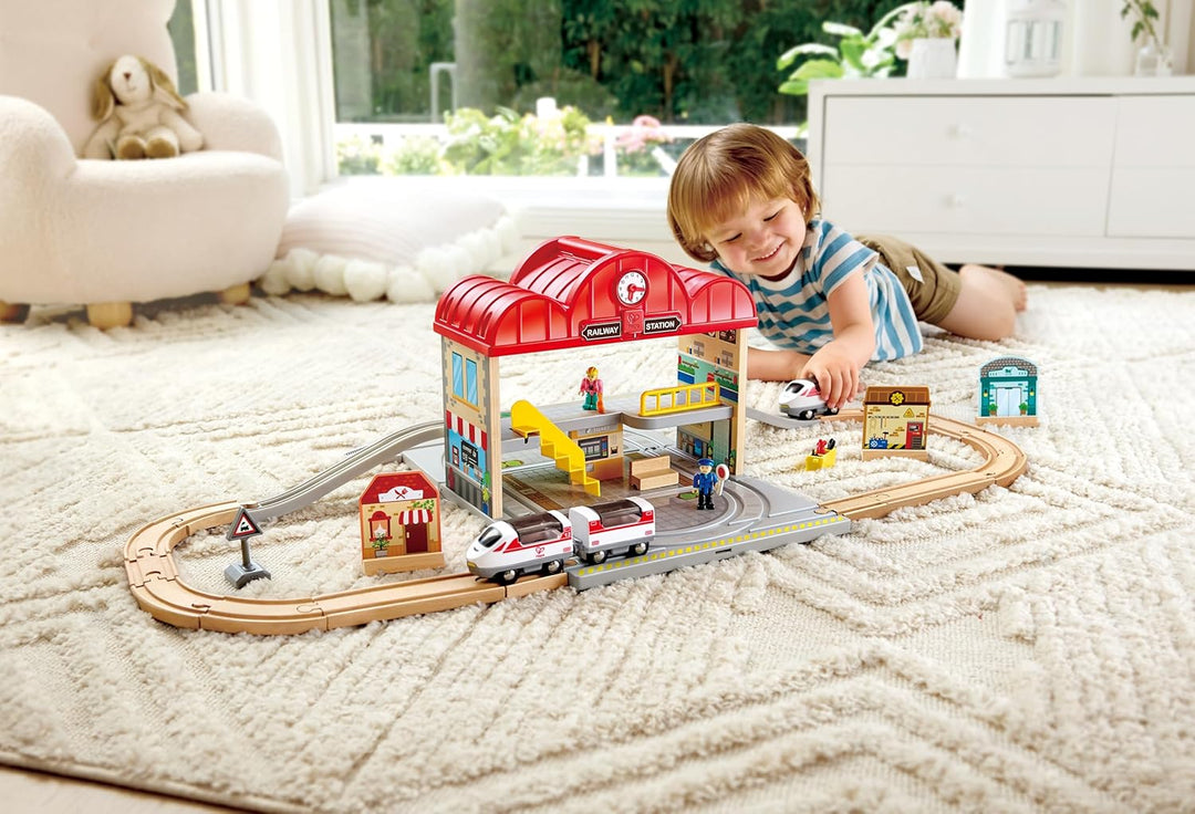 Hape Tragbares Bahnhof-Set aus Holz, Züge für Kinder, Schienen, Bahnhof und Figuren, leicht zu trage