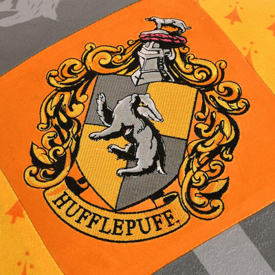 Elbenwald Harry Potter Kissen mit Quasten im Hufflepuff Design mit gesticktem Wappenpatch in den Hau