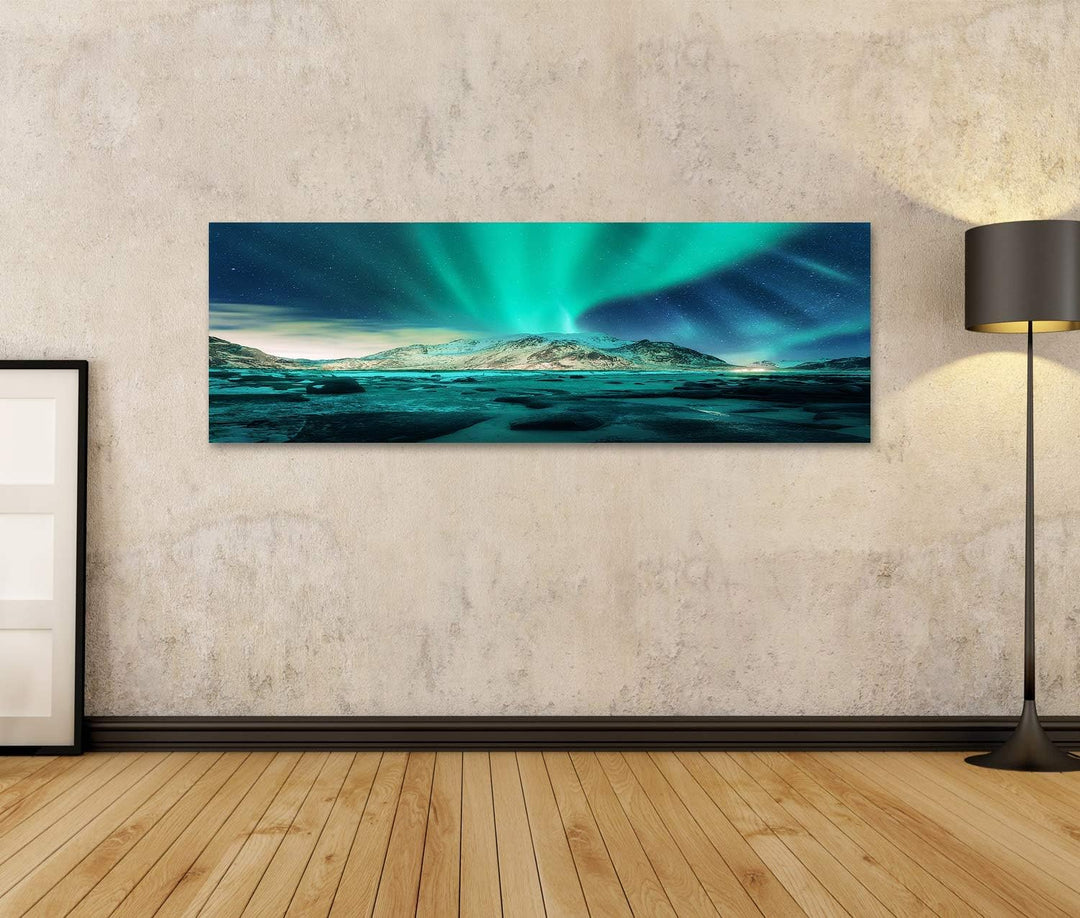 Bild auf Leinwand Aurora über verschneite Berge, Sandstrand mit Steinen. Nordlicht auf den Lofoten,