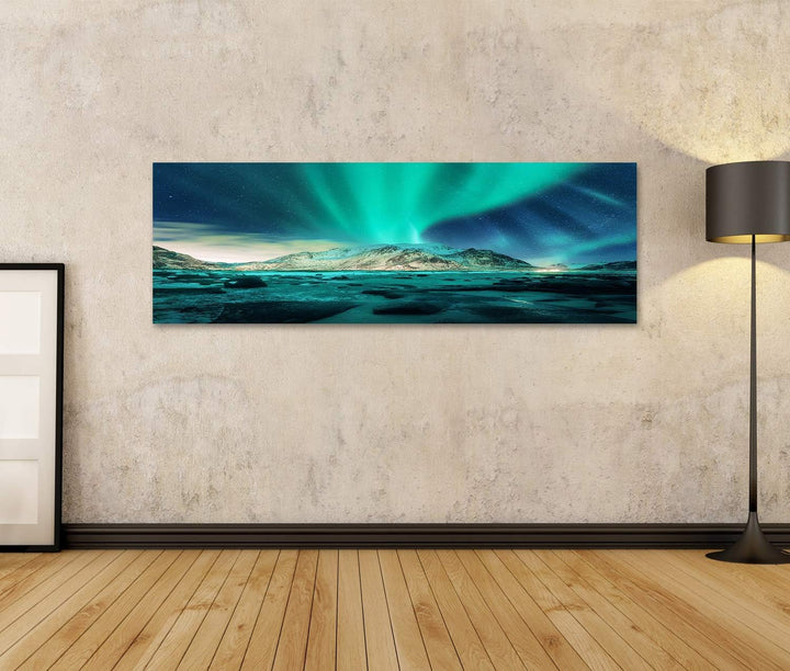 Bild auf Leinwand Aurora über verschneite Berge, Sandstrand mit Steinen. Nordlicht auf den Lofoten,