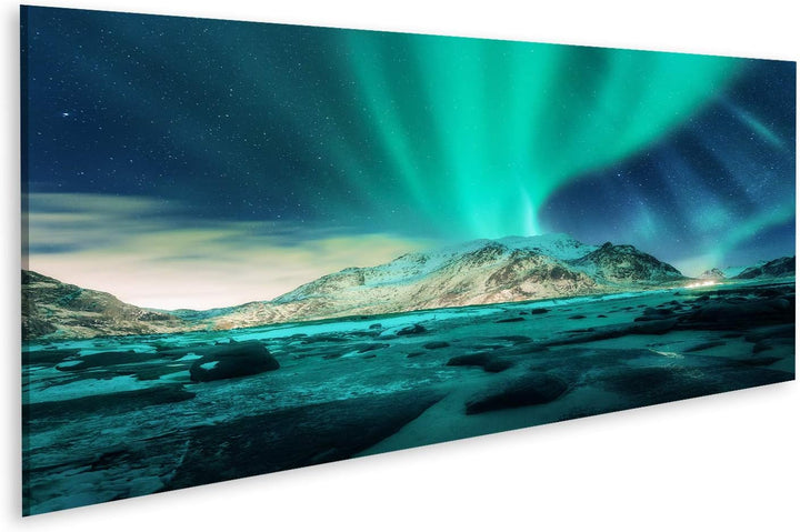 Bild auf Leinwand Aurora über verschneite Berge, Sandstrand mit Steinen. Nordlicht auf den Lofoten,