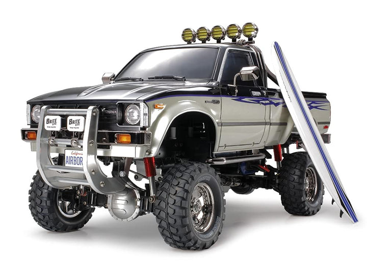 TAMIYA TMYTAM58397 1:10 RC Toyota HiLux HighLift 4x4 3-Gang - ferngesteuertes Auto - inkl. Surfbrett