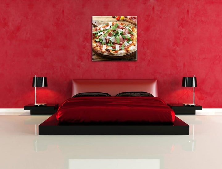 Pixxprint Prosciutto Pizza mit Rucola und Parmesan auf rustikalem Holztisch, Format: 70x70 auf Leinw