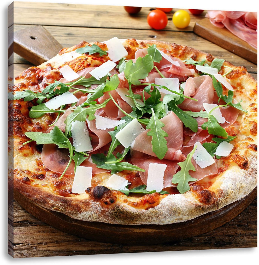 Pixxprint Prosciutto Pizza mit Rucola und Parmesan auf rustikalem Holztisch, Format: 70x70 auf Leinw
