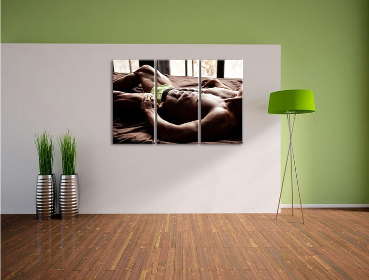 Pixxprint Muskulöser Mann im Bett als Leinwandbild | Grösse: 3 Teilig (120x80) | Wandbild| Kunstdruc